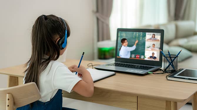 The Children’s Online Privacy Protection Act is designed to protect children under 13 from having their personal information collected on the internet. Image shows a young girl using a laptop for remote learning.